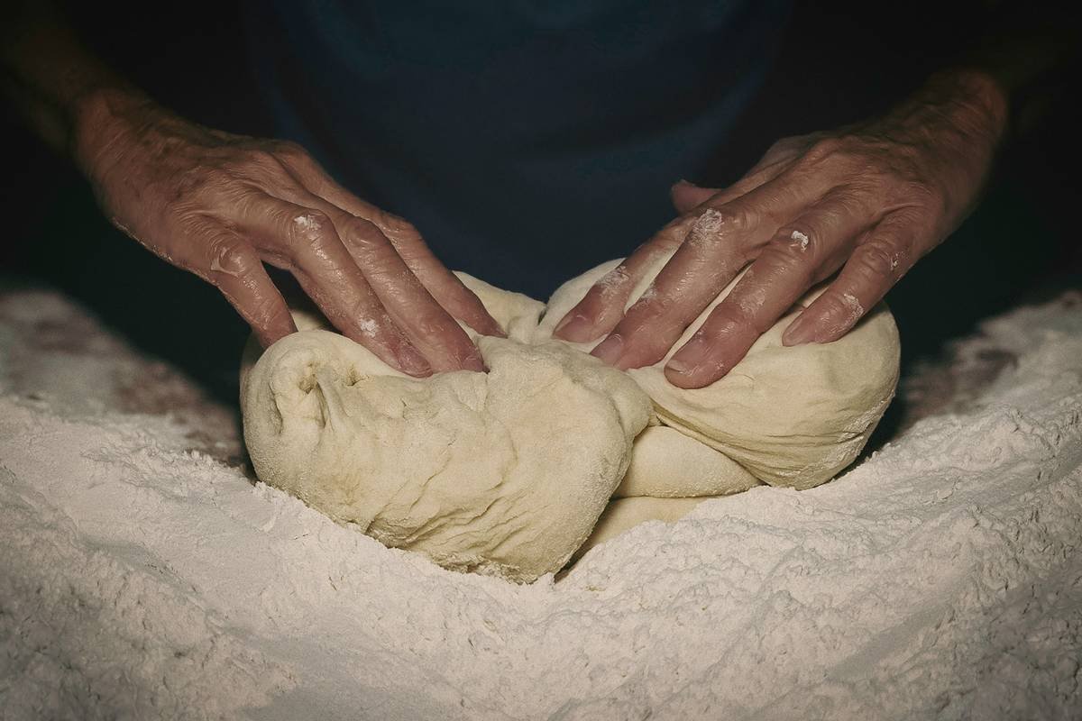 Infographic showing gluten strand formation during mechanical vs. hand kneading