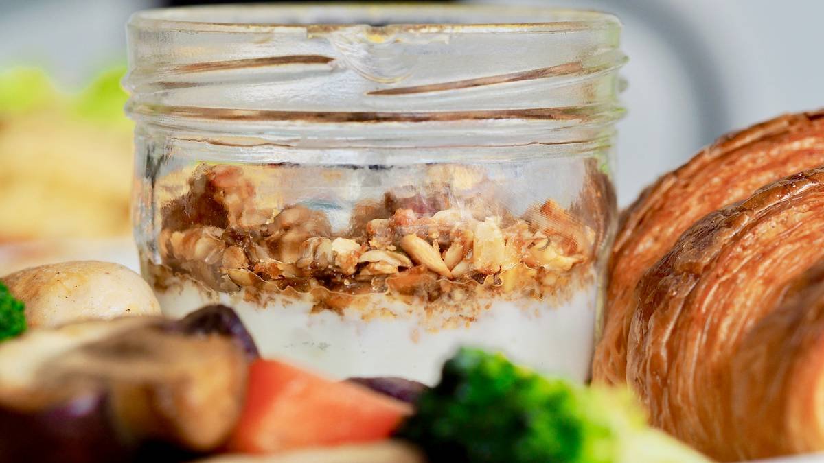 Infographic showing how steam trapped in a glass jar during baking creates better oven spring and crust development compared to open-air baking